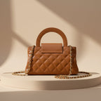 Brown handbag with a gold chain on a white background