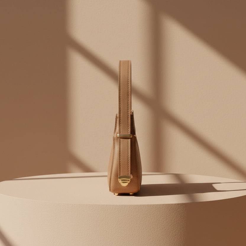 Tan handbag with a gold clasp on a white background